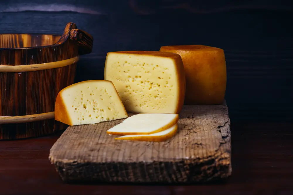 Block-of-cheese-on-old-wooden-table