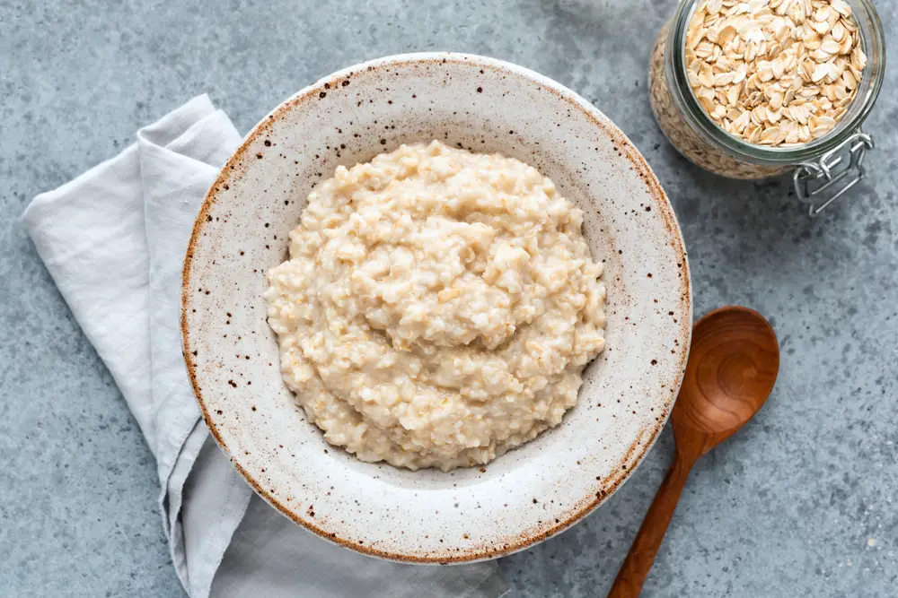 Bowl of plain oatmeal with oats so you can eat oatmeal after tooth extraction