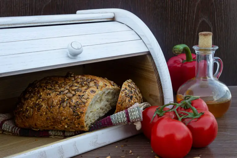 Fresh-baked-whole-grain-bread-on-dish-towel-inside-wooden-bread-box