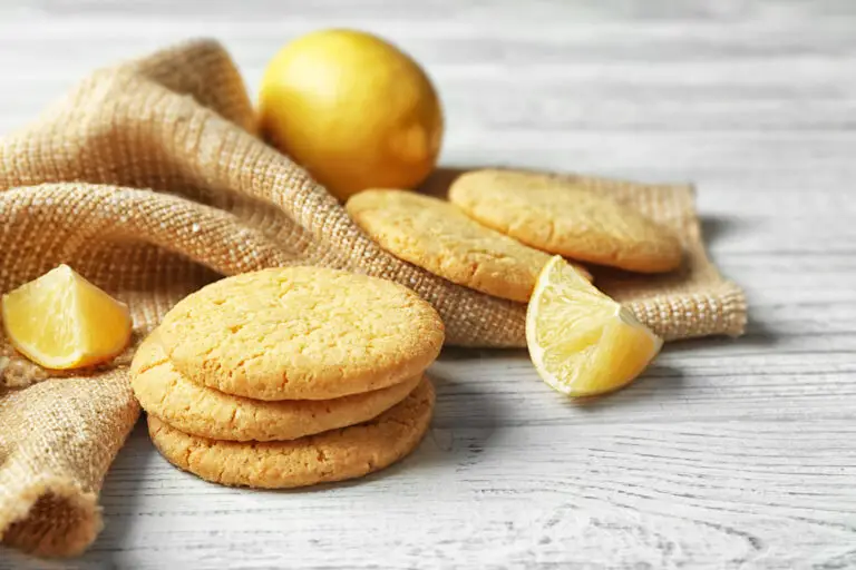 Homemade-lemon-cookies-with-lemon-and-lemon-slices-on-yellow-dish-towel.