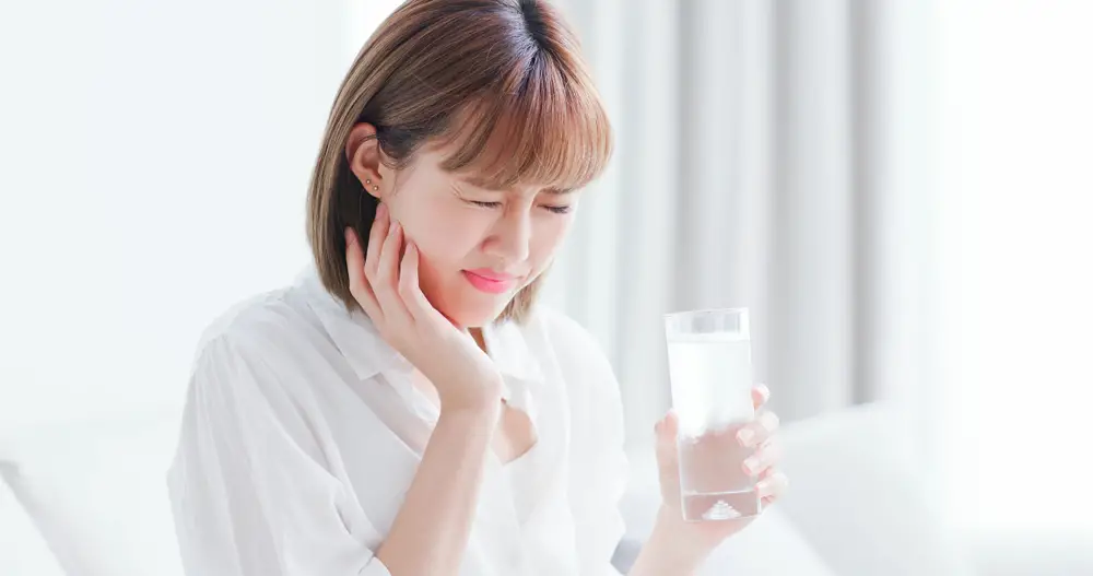 woman drinking water after tooth extraction