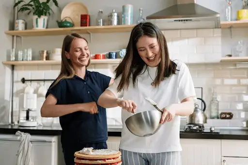 Woman and teenage daughter baking cake together